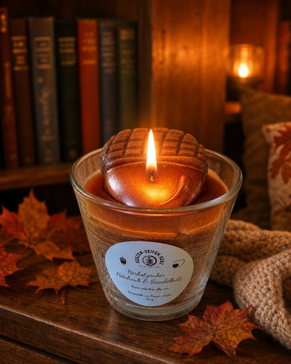 Herbstzauber-Duftkerze im Glas vor einem Regal in warmer und gemütlicher Wohnatmosphäre