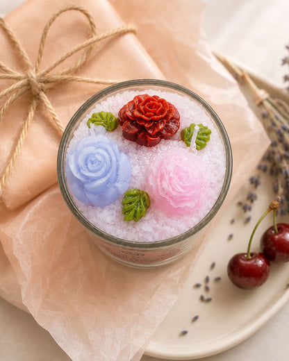 Lavendel-Kirsch Duftkerze im Glas auf rosé Geschenkpapier mit Lavendel und Kirschen