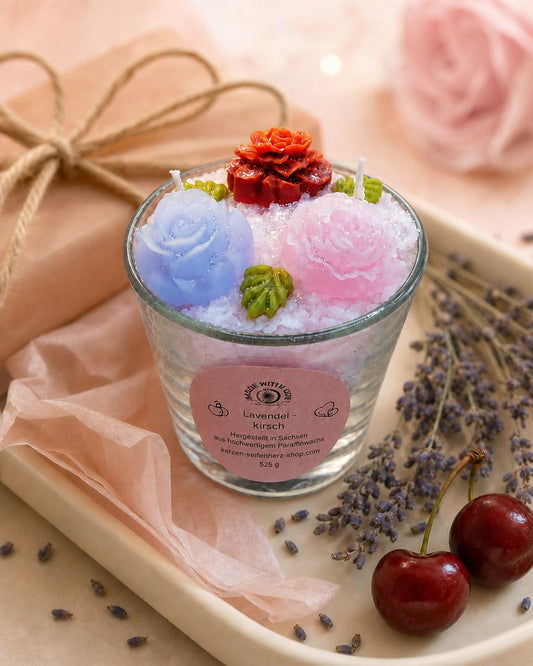Handgemachte Lavendel-Kirsch Duftkerze im Glas auf Geschenkpapier mit Lavendel und Kirschen