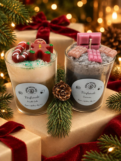 Weihnachtskerzen-Set mit Vanillecake und Tiramisu gemeinsam auf Geschenkbox mit roter Schleife und Tannenzweig