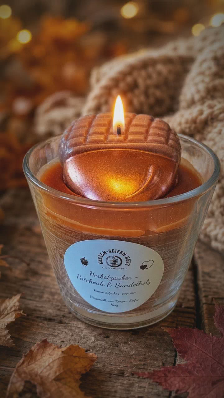 Herbstzauber-Duftkerze mit Flamme zwischen natürlichen Herbstmaterialien und gemütlicher Dekoration